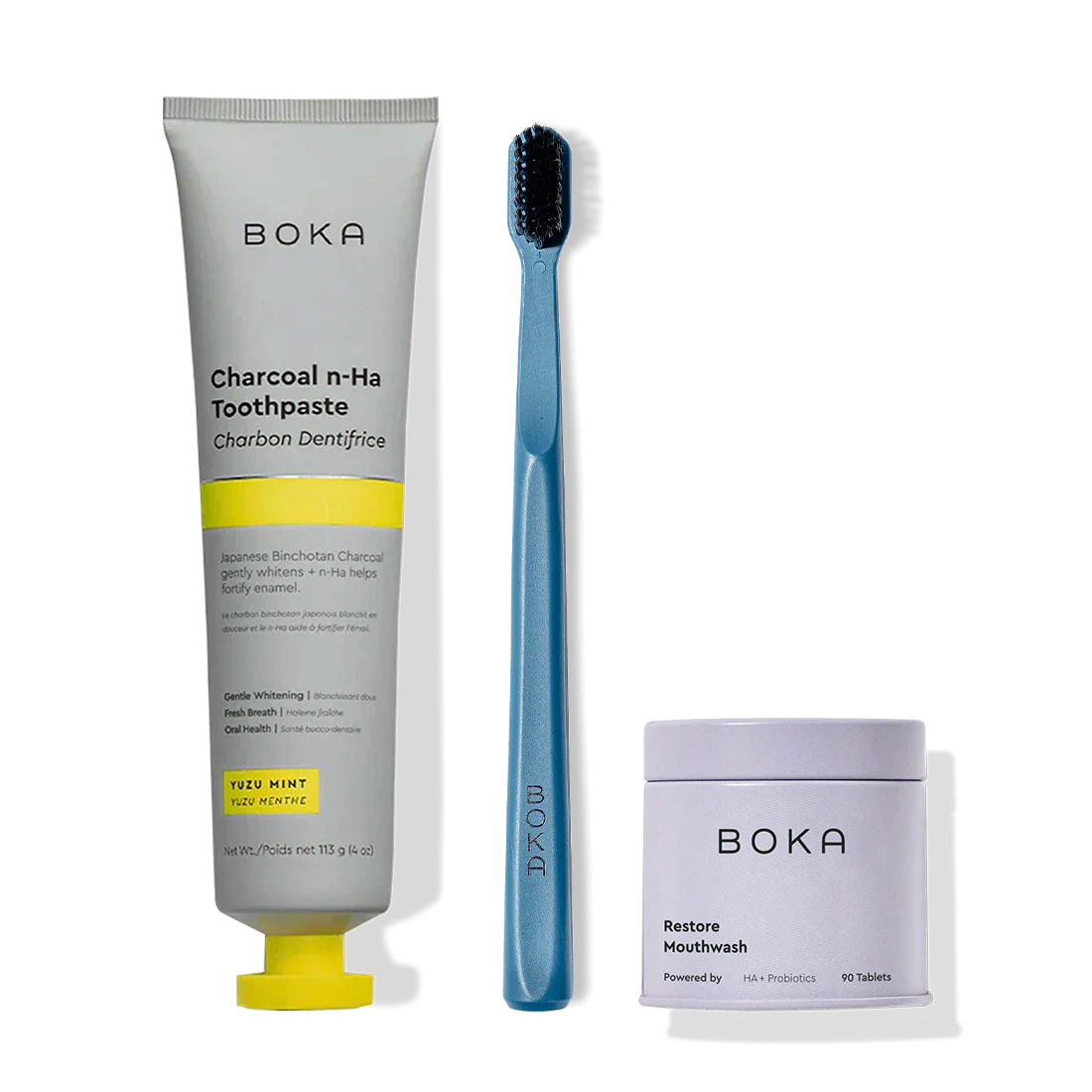 Fresh Faced toothpaste, blue charcoal toothbrush, and Restore Mouthwash tablets on black.