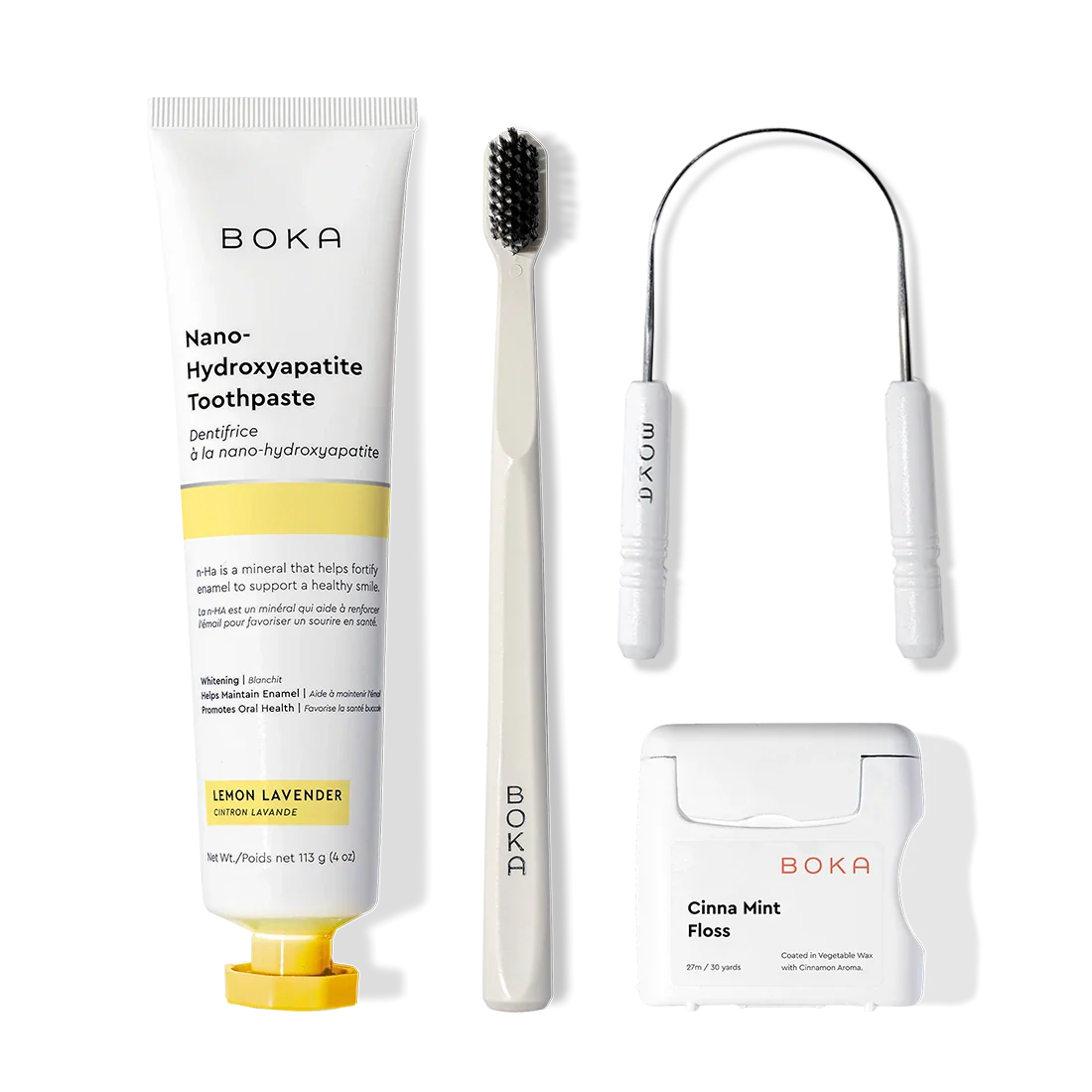 Starter Kit with toothpaste, charcoal toothbrush, tongue cleaner & floss on a plain background.