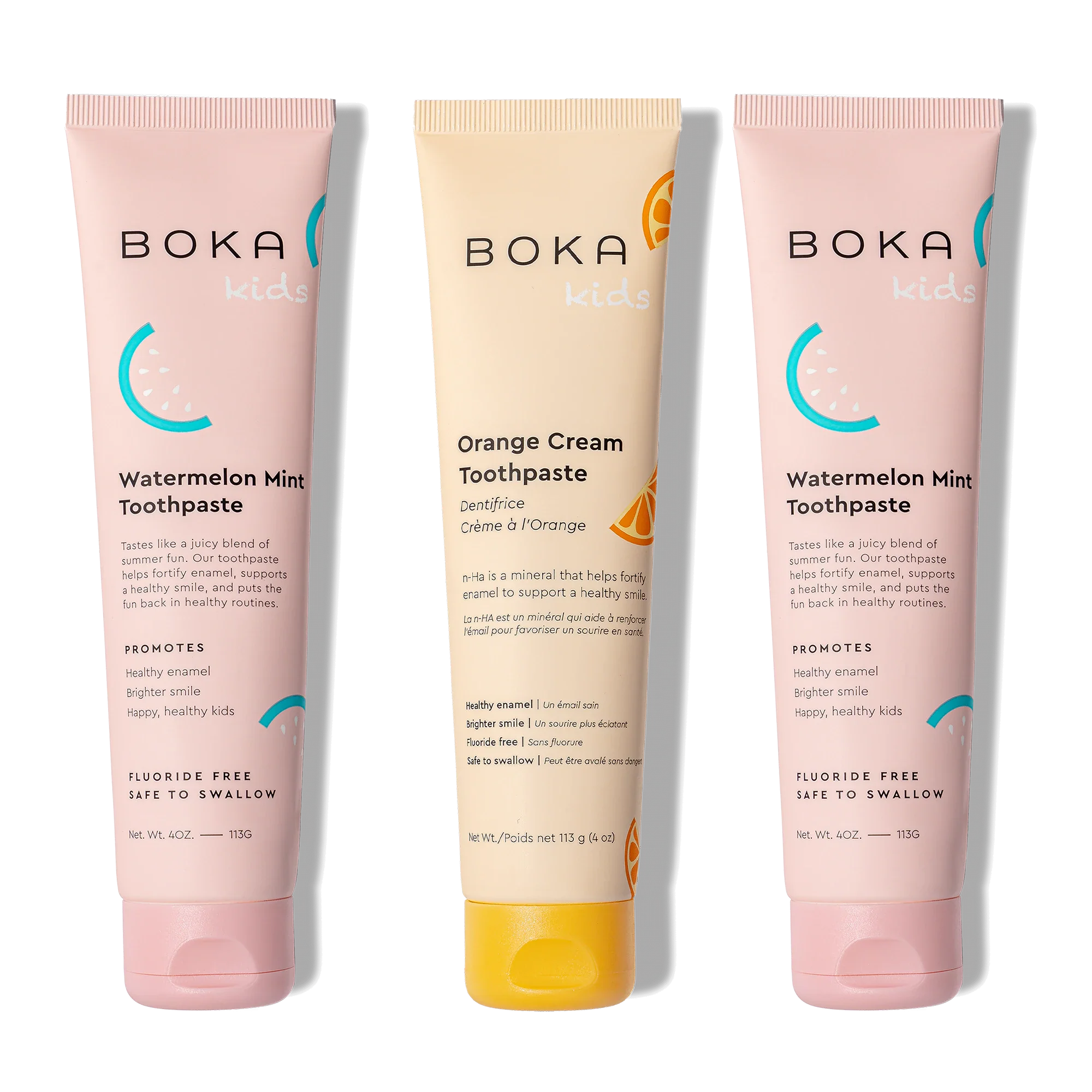 Three tubes of Boka toothpaste, two pink and one orange, on a white background.